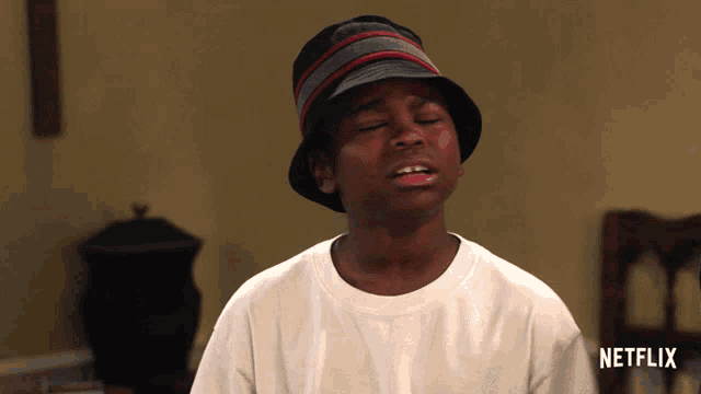 a boy wearing a hat and a white shirt with netflix written on the front