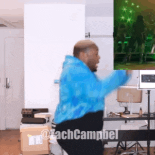 a man in a blue tie dye jacket is dancing