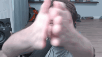 a man is making a peace sign with his hands while wearing headphones