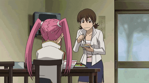 a girl with pink hair is sitting at a table with a woman