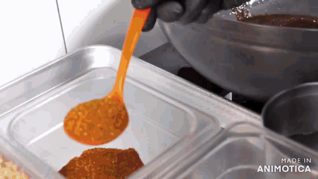 a person is pouring a sauce into a plastic container that says made in animonica