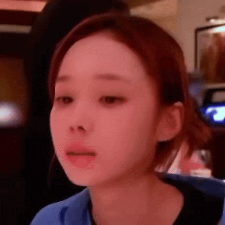 a close up of a woman 's face with a red background and a blue shirt .