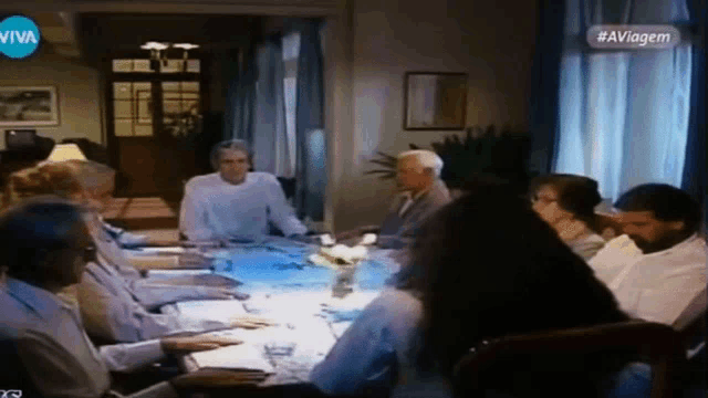 a group of people are sitting around a table with a sign that says viva on it