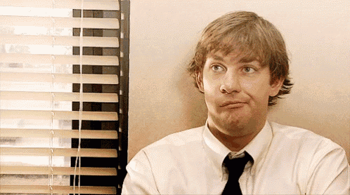a man in a white shirt and tie is making a face