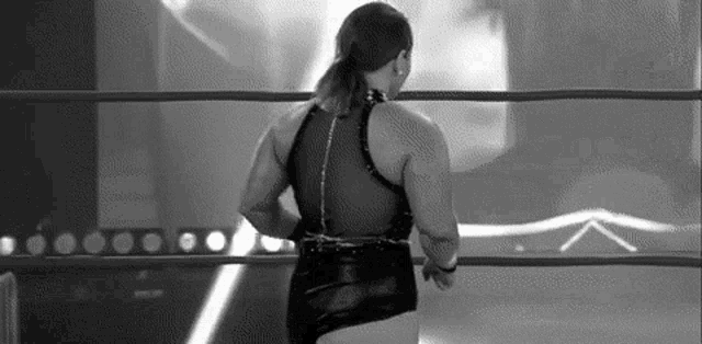 a black and white photo of a female wrestler in a wrestling ring .