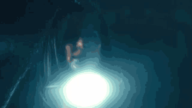 a person is holding a flashlight in their hand in the dark .