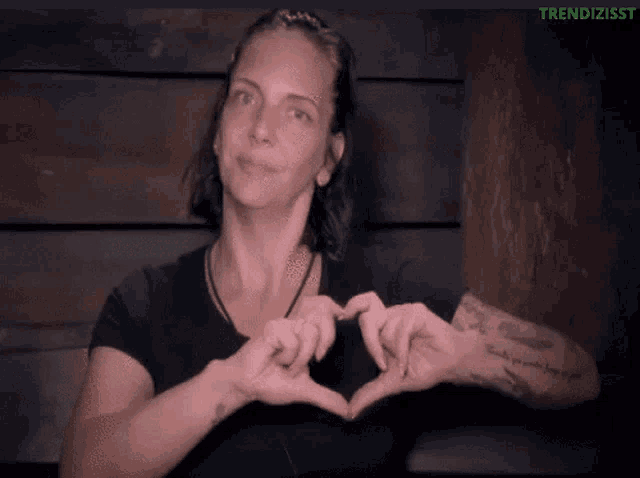 a woman making a heart shape with her hands with the words trendizisst on the bottom right
