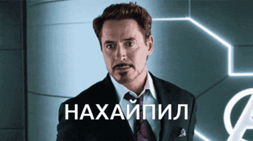 a man in a suit and tie stands in front of a sign that says ' haxapiil ' on it