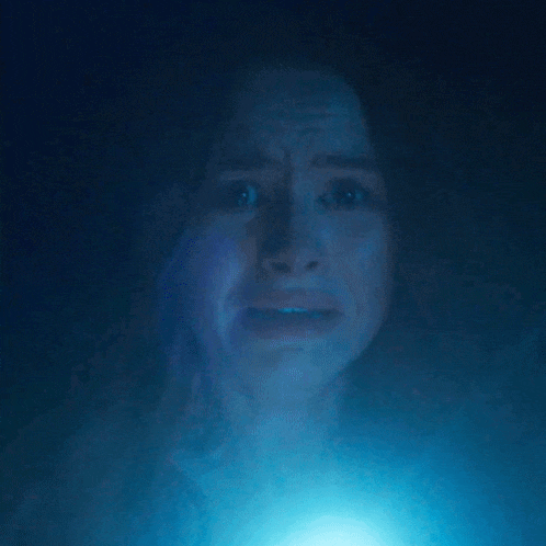 a close up of a woman 's face with a blue light in the background