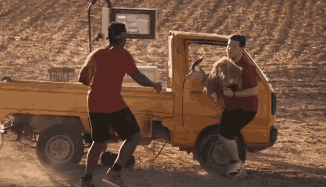 a man holds a goat in the back of a truck