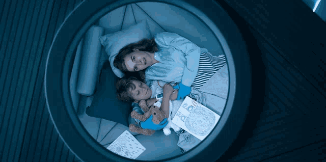 a woman and a child are laying in a circle reading a book called the book of pooky