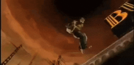 a man is jumping in the air in front of a building with a clock on it .