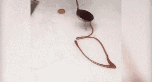 a person is drawing a musical note with chocolate .