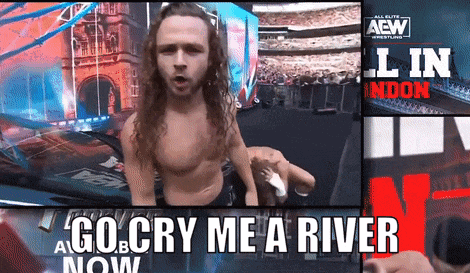 a man with long hair is standing in front of a sign that says go cry me a river
