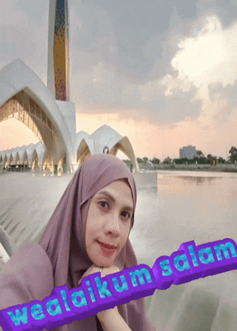 a woman wearing a purple hijab stands in front of a mosque with the words wedaikum salam written on the bottom