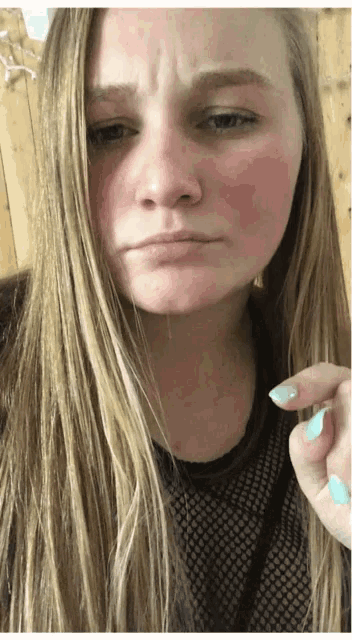 a woman with long blonde hair is making a silly face