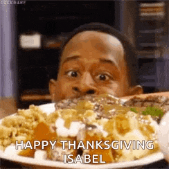 a man is eating a plate of food with a happy thanksgiving isabel message .