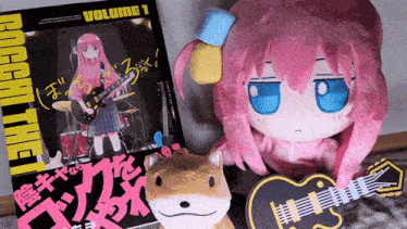 a stuffed animal is sitting next to a book that says rock the volume 1