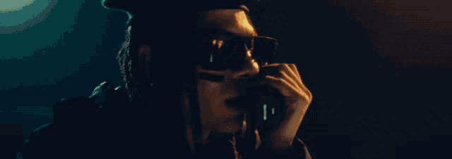 a man wearing sunglasses and a hat is holding a binoculars