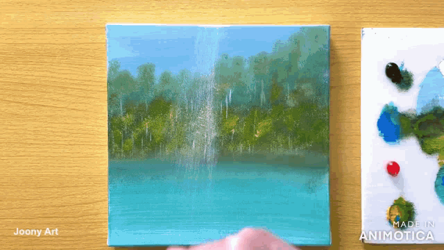 a painting by joony art is on a wooden table next to a palette