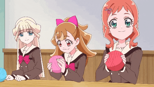 three anime girls sitting at a table holding balls of yarn