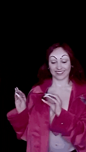 a woman in a pink jacket is holding a cell phone