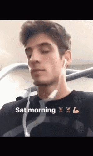 a man wearing ear buds and a black shirt with the words sat morning written on it
