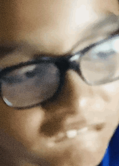a close up of a person wearing glasses making a funny face