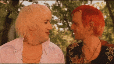 a man with red hair and a woman with blonde hair are looking at each other