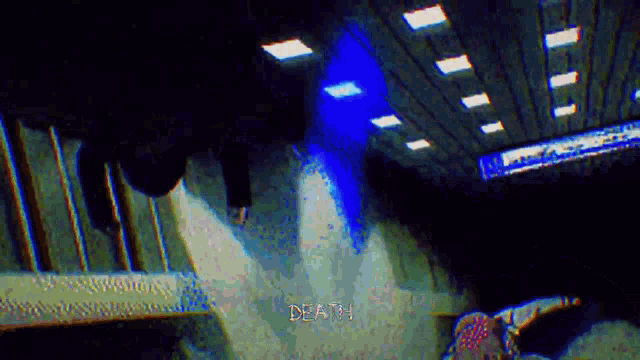 a person is walking down a set of stairs in a dark room with a blue light coming from the ceiling .