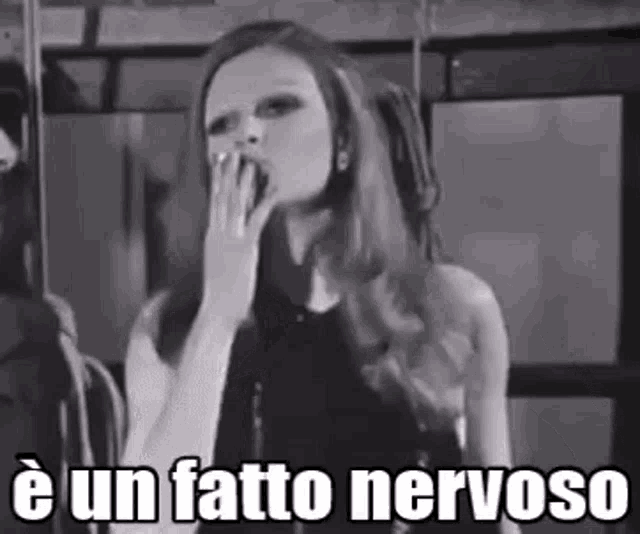 a black and white photo of a woman yawning with the words e un fatto nervoso written below her .