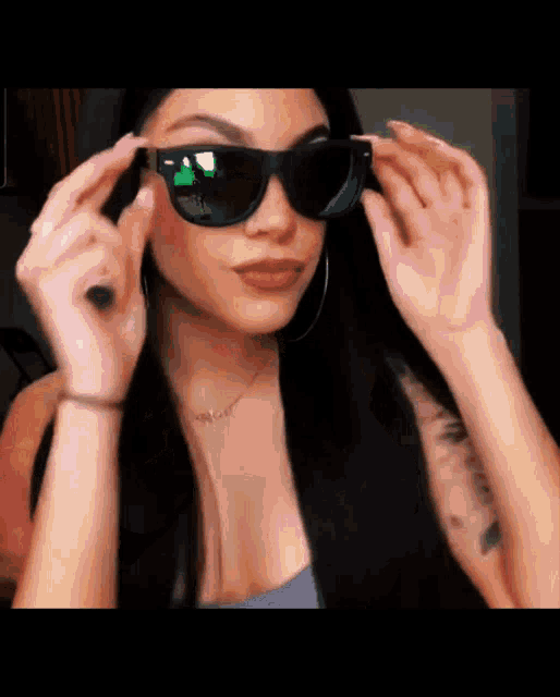 a woman wearing sunglasses with a necklace that says ' i love you ' on it