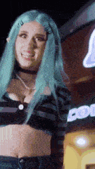a woman with blue hair and a choker is smiling