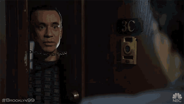 a man is pointing at another man in front of a door with the number 3c on it