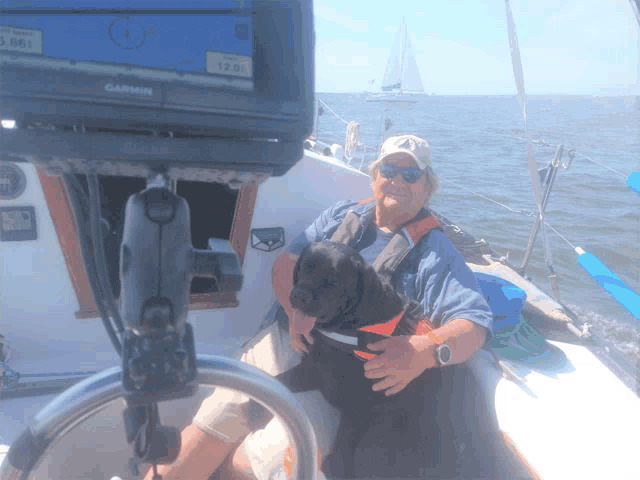 a man and a dog on a boat with a garmin gps in the background