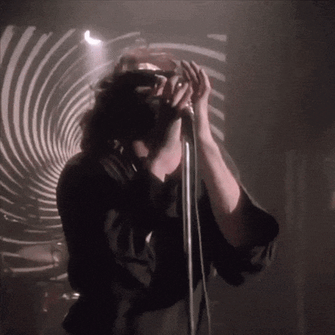 a man is singing into a microphone with a swirl in the background .