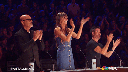 a group of people applauding with a nbc logo in the background