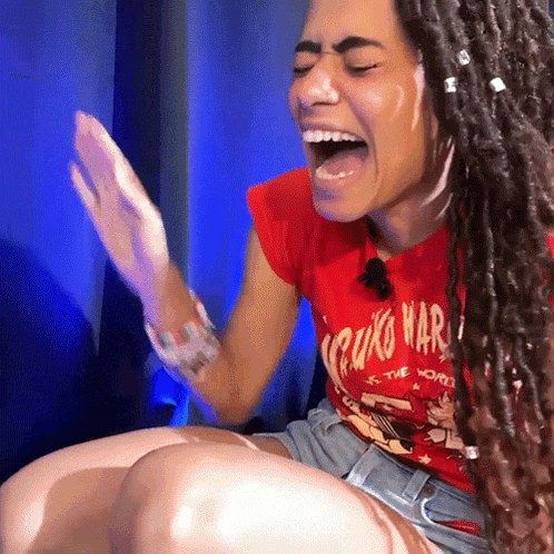 a woman wearing a red shirt that says cruzo mar is laughing with her mouth open