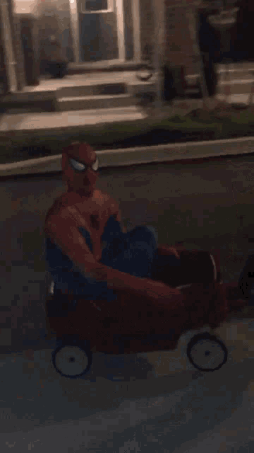 a person in a spiderman costume is laying on a sidewalk