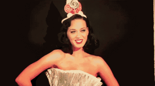 a woman wearing a dress and a crown with lollipops on it .