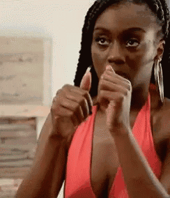 a woman in a red tank top is giving a thumbs up .