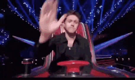 a person is pressing a red button on a stage with a lot of lights behind them .
