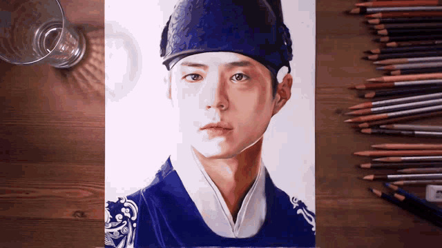 a drawing of a man in a blue hat is on a wooden table