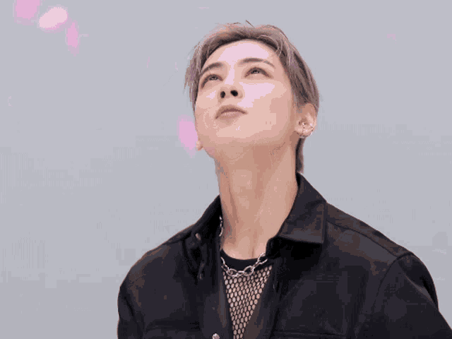 a close up of a man with pink petals falling on his face