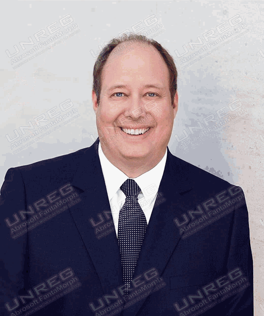 a man in a suit and tie is smiling in front of a white background with the words unreg