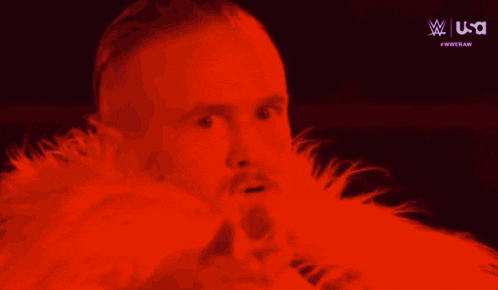 a man wearing a pink fur coat is pointing at something .