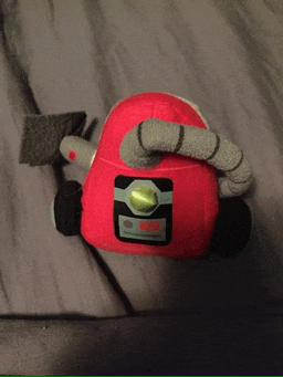 a stuffed toy that looks like a vacuum cleaner with a yellow button