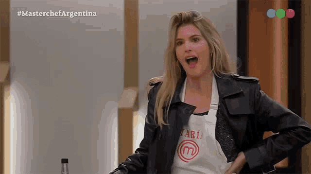 a woman wearing a leather jacket and an apron that says masterchef argentina