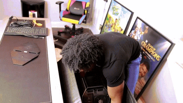 a man is working on a computer in front of a poster that says wwe champions