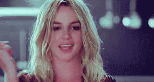 a close up of a woman 's face with blonde hair and a smile on her face .